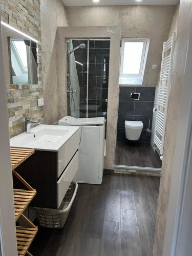 a bathroom with a sink and a tub and a toilet at Gîte les cigognes in Steinbourg