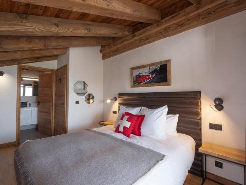a bedroom with a large bed with red pillows at Appartement avec Sauna et Jacuzzi aux Saisies - FR-1-809-14 in Les Saisies