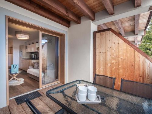 ein Esszimmer mit einem Glastisch und einer Holztür in der Unterkunft Appartement charmant 4 pers, piste proche, parking, Les Saisies - FR-1-809-13 in Les Saisies