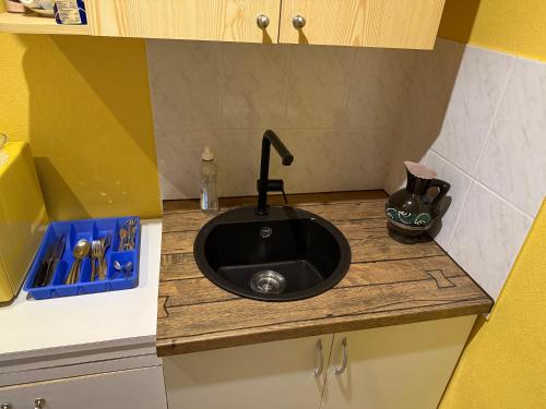 a kitchen counter with a black sink in it at Rüütli - Cute Old Town Apartment - 2 big beds, free parking in Tartu