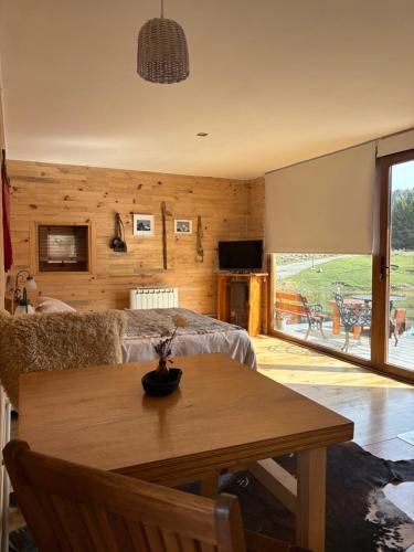 a living room with a table and a couch at Wau Purul, Cabaña 2 in Cholila