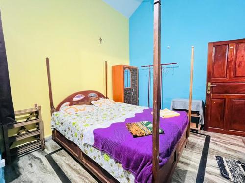 a bedroom with a canopy bed with purple sheets at Mayelle Agonda in Agonda