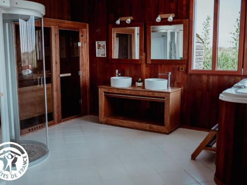 une salle de bain avec deux lavabos et un miroir dans l'établissement Gîte 4 chambres avec bien-être et terrasses au cœur du Marais Breton - FR-1-426-559, à Bois-de-Cené