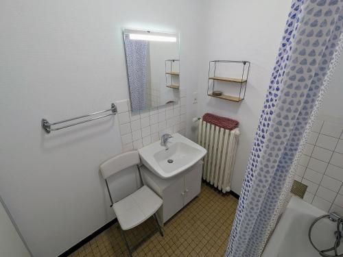 une salle de bain blanche avec un lavabo et un miroir dans l'établissement Appartement rénové au pied des Mille Étangs, 3 chambres - FR-1-583-410, à Mélisey