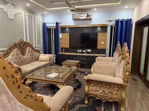 ein Wohnzimmer mit zwei Stühlen und einem Fernseher in der Unterkunft Aolai hotel in Islamabad