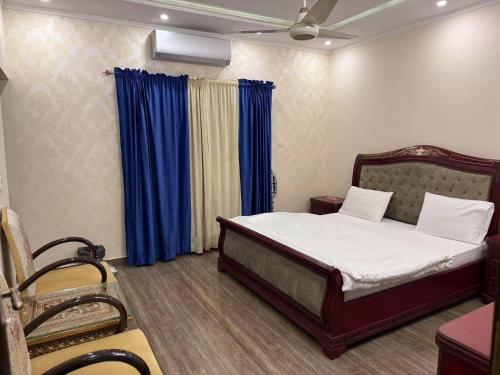 ein Schlafzimmer mit einem Bett und einem blauen Vorhang in der Unterkunft Aolai hotel in Islamabad