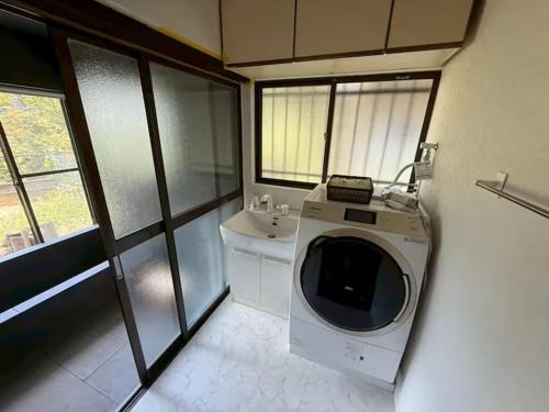 eine Waschmaschine im Bad mit Waschbecken in der Unterkunft Boogie Garden - Vacation STAY 06312v in Miyakami