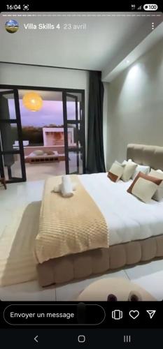 a room with a large bed with a window at Villa Palms Marrakech in El Aggada