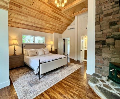 a bedroom with a bed and a stone wall at The Pink House in Banner Elk