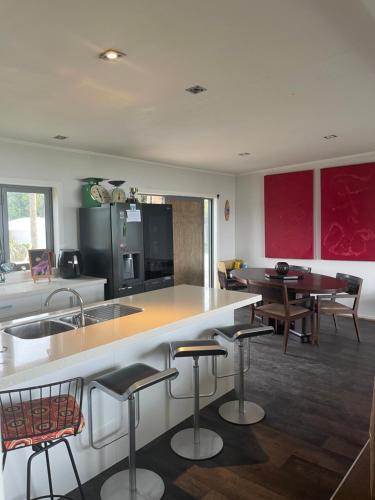 une cuisine avec un comptoir et des tabourets dans une pièce dans l'établissement Ocean Shores Warea, 