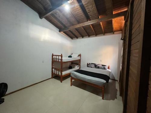 1 dormitorio con cama y estante en Aconchego da Praia, en Imbituba