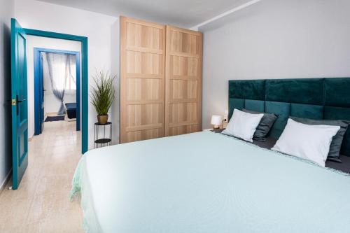 a bedroom with a large bed and a blue door at Rinconcito de Catalina in Torrevieja