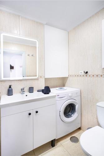 a white bathroom with a washing machine and a sink at Rinconcito de Catalina in Torrevieja