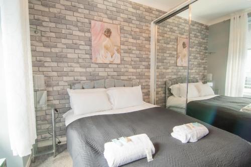 une chambre avec un lit et un mur de briques dans l'établissement Central Renfrew 1BR Apt, à Renfrew