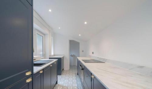 Una cocina grande con fregadero y encimera. en Cozy 2 Bedroom Macclesfield House, en Macclesfield