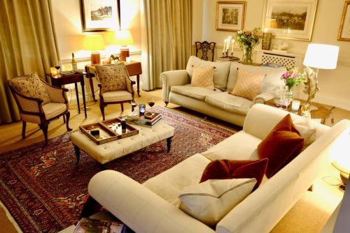 un soggiorno con un divano bianco e sedie di Finstock Manor a Finstock