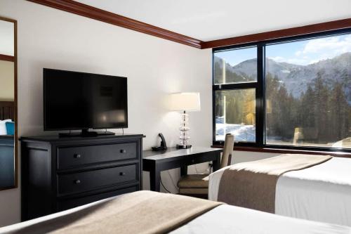 a bedroom with two beds and a desk with a television at Studio Suite 2 Queen Beds Mountain View in Tahoe City