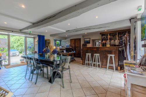 comedor con mesa y bar en Logis Hôtel Le Manoir Des Portes, en Lamballe
