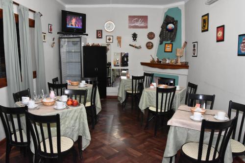 a dining room with tables and chairs and a fireplace at Residencial El Hogar in Salta