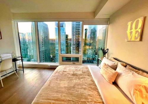 ein Schlafzimmer mit einem großen Bett und einem großen Fenster in der Unterkunft Altitude One - Skyline Residences Montreal in Montreal