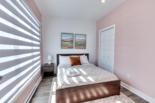 ein kleines Schlafzimmer mit einem Bett und einem Fenster in der Unterkunft Modern Comforts 3 Bedroom & Full Kitchen & Wifi & Easy Montreal Access in Longueuil