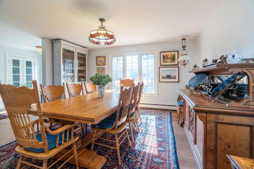a dining room with a wooden table and chairs at Blue Ocean Cove Beach House in Saint Peters