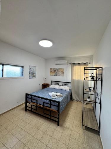 una camera da letto con un letto e uno scaffale al suo interno di Best sea view a Qiryat Yam