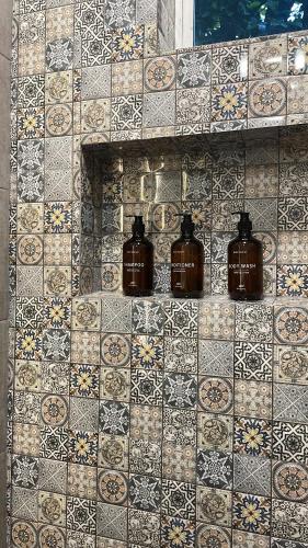 a tiled wall with four jars on it at Montería, MonteCapi in Montería