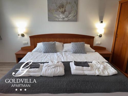 a bedroom with a bed with towels on it at Goldvilla Apartman in Zalakaros