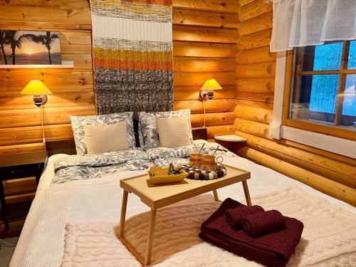 ein Schlafzimmer mit einem Bett und einem Tisch darauf in der Unterkunft Kantolammen mökki 66m2, kylpypalju ja puusauna in Kuusamo
