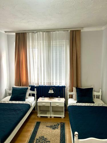 a bedroom with two beds and a window at "Rooms G" in the City centre in Valjevo