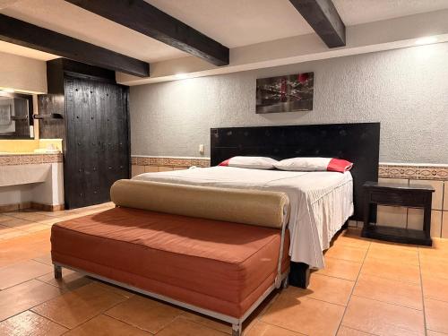 1 dormitorio con 1 cama grande y 1 reposapiés en Hotel Mirage Express, en Matamoros