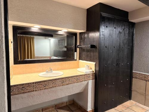 un baño con lavabo y espejo en Hotel Mirage Express, en Matamoros