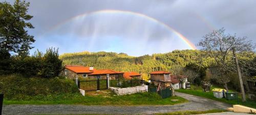 a rainbow in the sky over a house at A casa do Porto cerca de Cedeira y de la playa de Pantín in Valdoviño