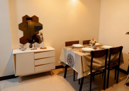 une salle à manger avec une table, des chaises et un miroir dans l'établissement Zen-Inspired 2 Bedroom Condo Satori Residences, à Manille