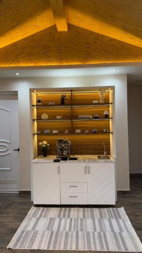 a kitchen with a white counter and a wooden wall at Sun Set Dunes Holidays Home