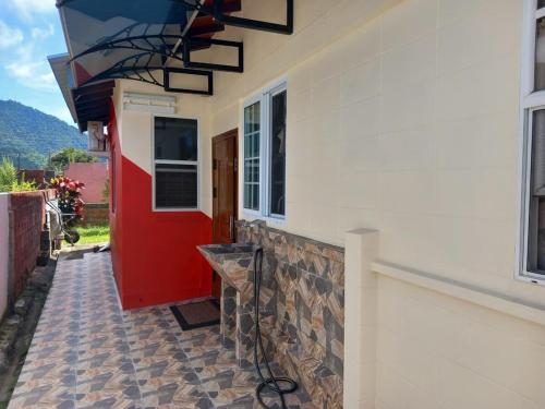 a house with a red and white wall and a window at Diamond Breeze - Fully furnished apartment in Port-of-Spain