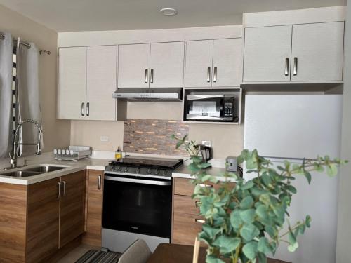a kitchen with white cabinets and a stove top oven at Amar Apartment - 24 hour security, Comfort in Tijuana