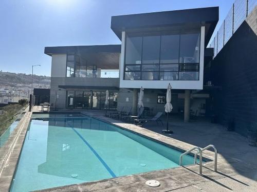 a large building with a swimming pool in front of it at Amar Apartment - 24 hour security, Comfort in Tijuana