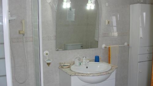 a bathroom with a sink and a shower with a mirror at Casa de Férias Azeitão in Azeitao