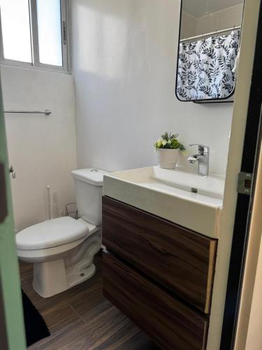 a bathroom with a white toilet and a sink at Amar Apartment - 24 hour security, Comfort in Tijuana