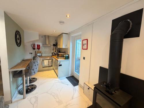 a kitchen with a stove in the middle of a room at Cardiff Coach House with Hot Tub & Log Fire in Cardiff