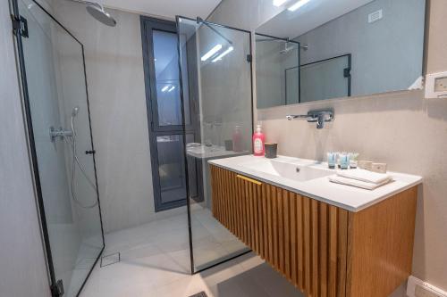 une salle de bain avec lavabo et douche dans l'établissement מיקונוס על הים נהריה, à Nahariya