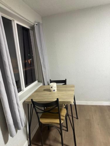 ein Tisch und Stühle in einem Zimmer mit Fenster in der Unterkunft The Mint Motel in Rock Springs