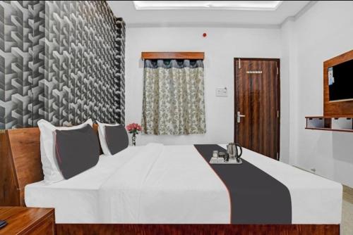 Un dormitorio con una cama blanca grande y una ventana en Hotel Shivaay, en Indore