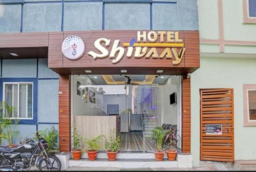 un hotel shiryiya con plantas delante de él en Hotel Shivaay, en Indore