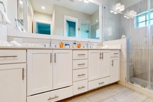 马士腾海滩Perfect Pelican at Palmilla Beach的白色的浴室设有2个盥洗盆和淋浴。