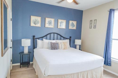 帕德雷岛Beach Club - Ocean Breeze Retreat – Island Condo的卧室里有一张床，墙壁是蓝色的