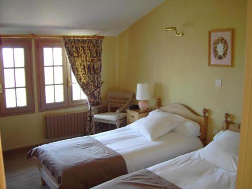 une chambre d'hôtel avec deux lits et une fenêtre dans l'établissement Auberge Des Chasseurs, à Échenevex