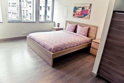 a bedroom with a bed with pink pillows at Appart-Hotel Léopold Liège Centre in Liège